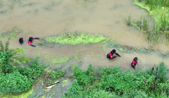9일 오후 경북 경산시 진량읍 평사리 문천지에서 소방구조대가 폭우에 실종된 여성을 수색하고 있다.<연합뉴스>